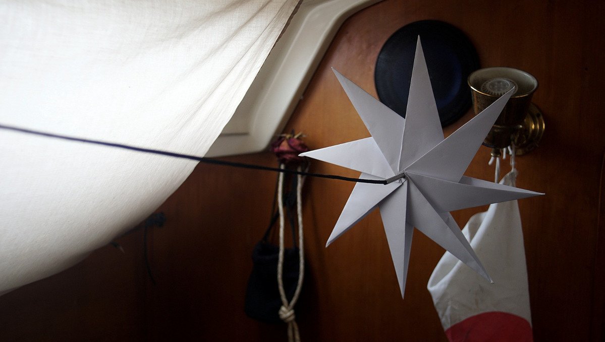 A photo of an origami star hanging on a rope aboard a sailboat