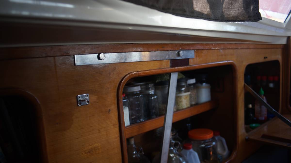 a length of metal linking the two upper bolt holes of two separate chainplates, and keeping them fixed to a wall inside a sailboat cabin. The starboard side.