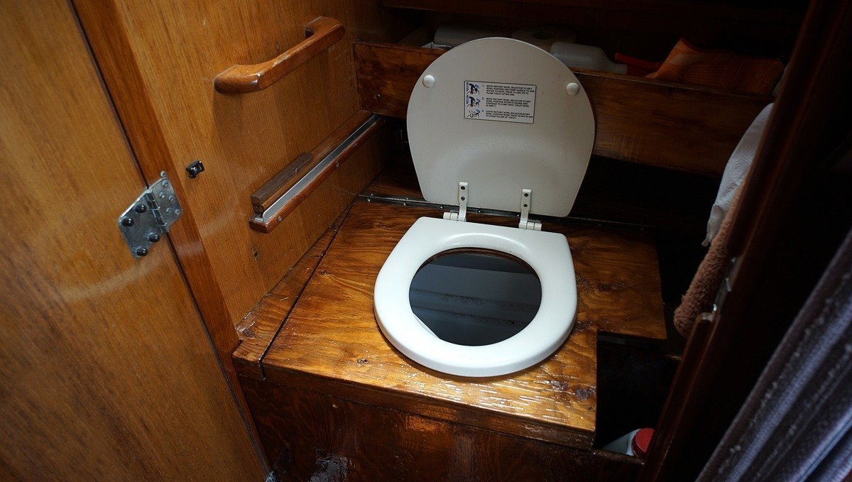 A photo of the dry toilet we built aboard our sailboat, with a wooden frame
