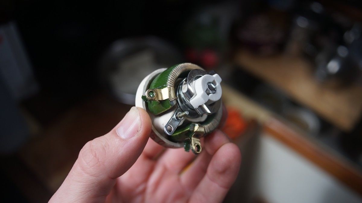 a photo of a hand holding a potentiometer, showing the front