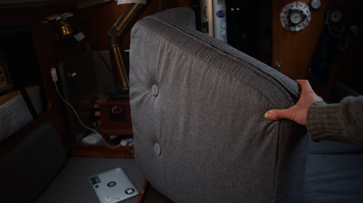 the underside of a newly-upholstered trapezoid cushion with buttons going through the cushion