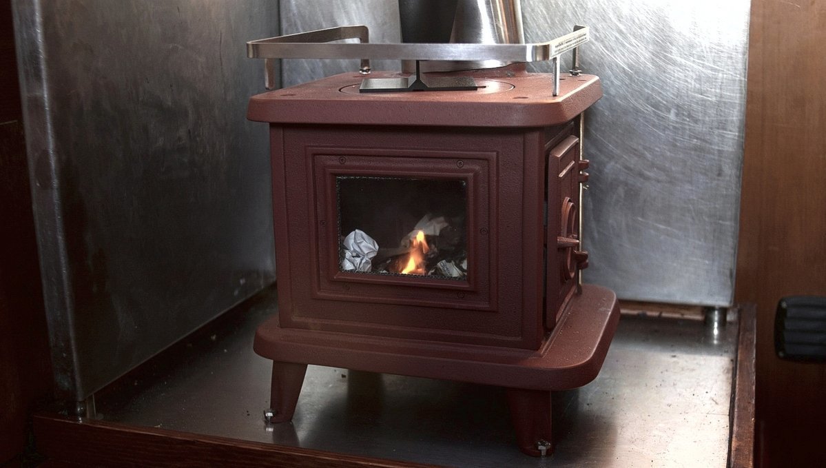 a sardine woodstove with a fire going inside