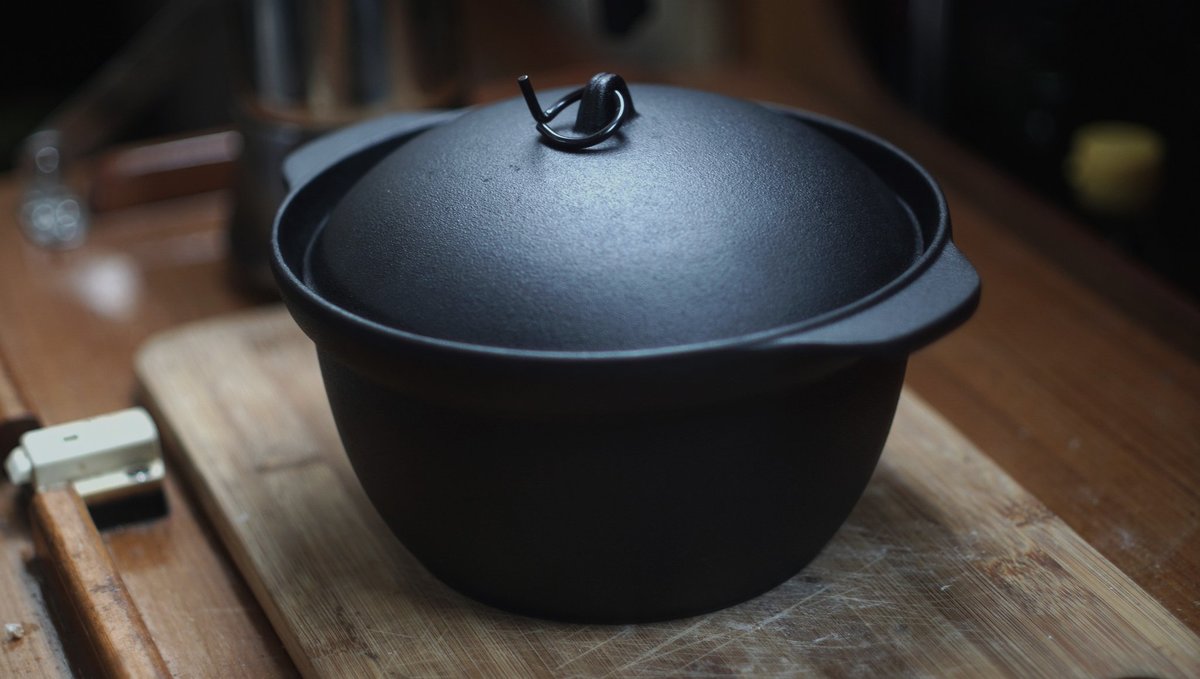 A photo of a cast-iron rice pot with a lid on a galley countertop