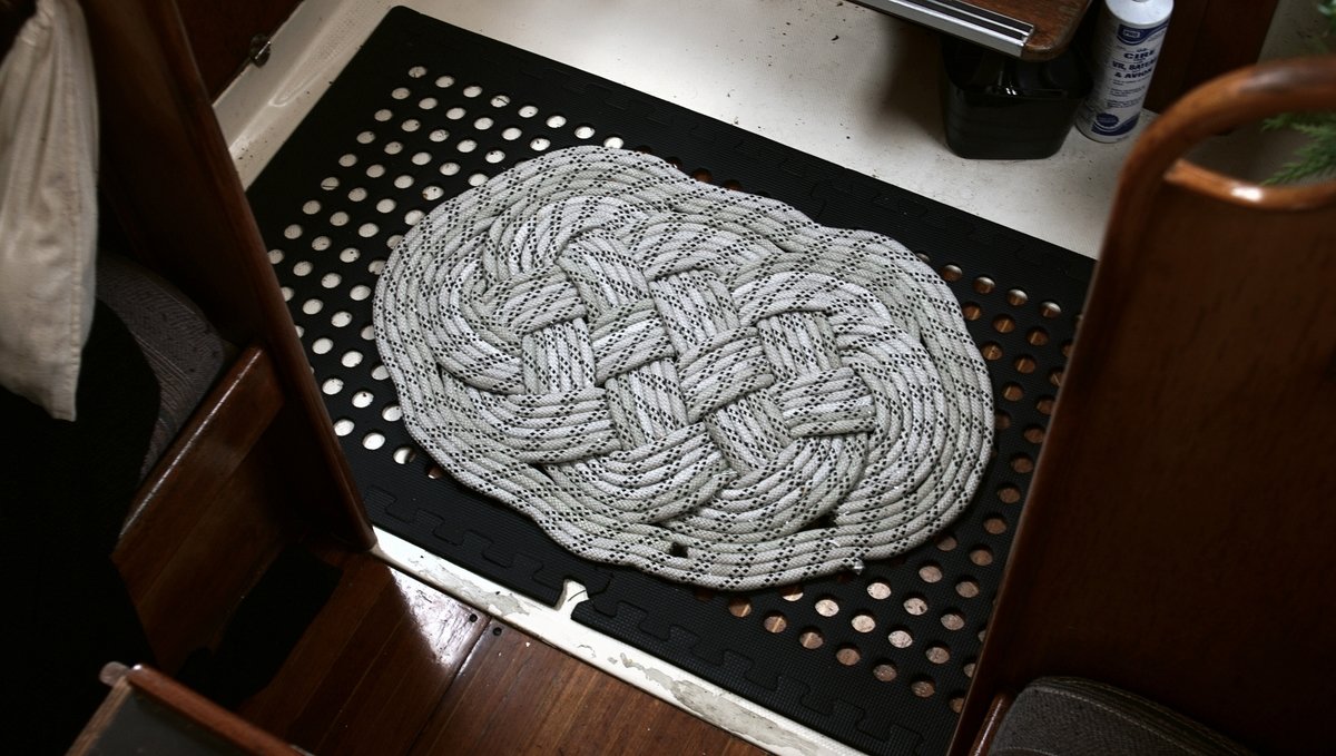 A photo of a mat made from an old main halyard on a sailboat galley floor