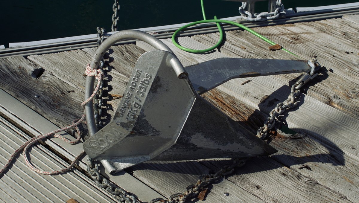 A photo of a 15kg Rocna anchor laying over its side on a dock