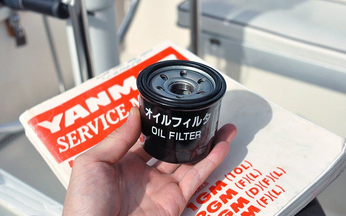 a hand holding an oil filter for diesel engines