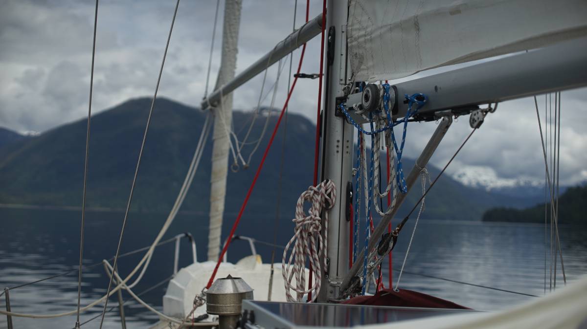 pino with a furled jib, with the whisker pole still on, with mountains in the background