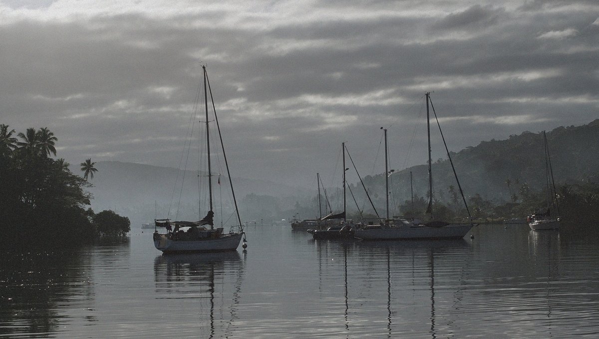 A photo of sailboats on moorings in Fiji on a grey, foggy day