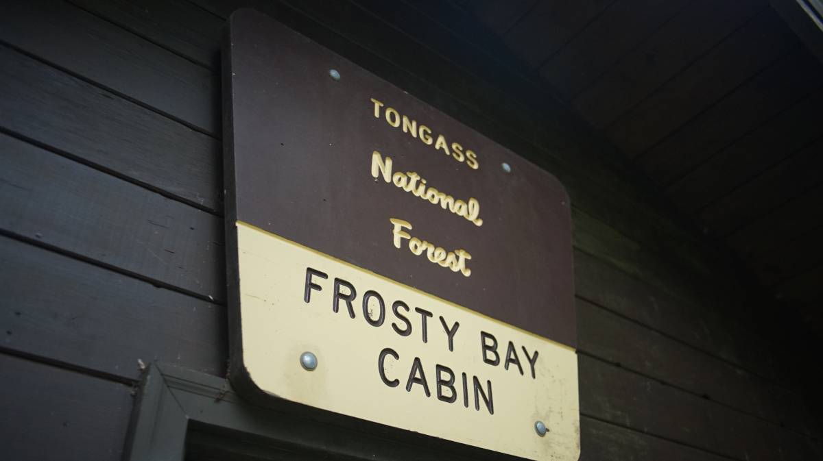 a sign reading frosty bay cabin, tongass national forest