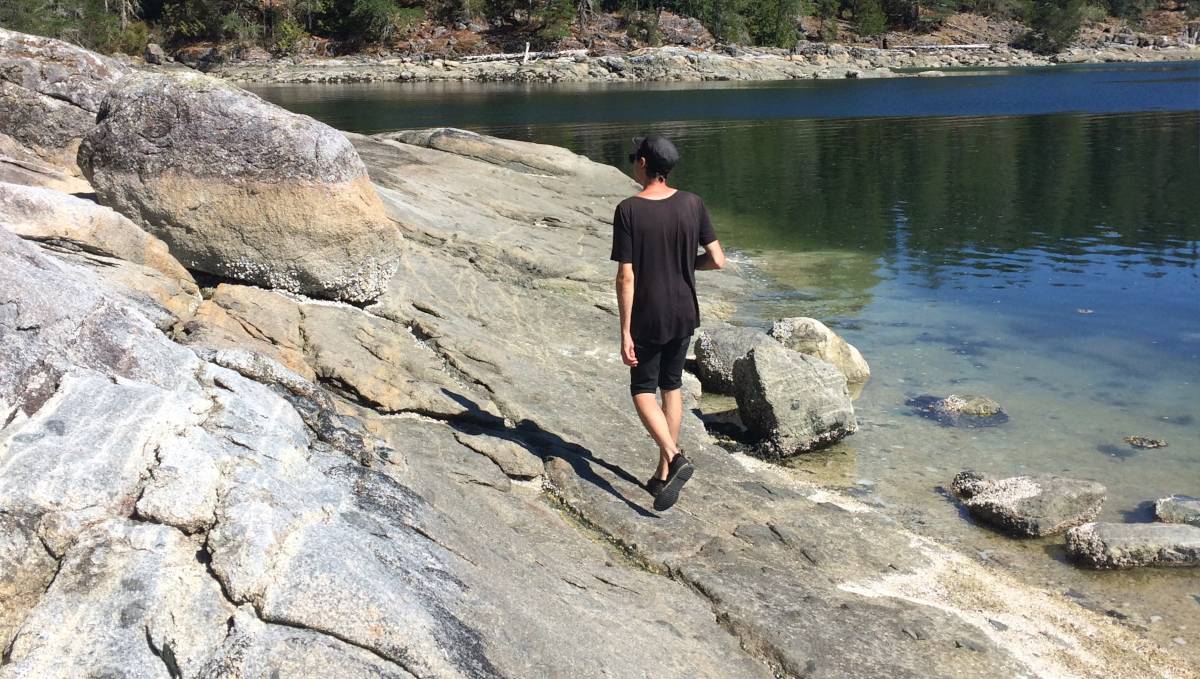 devine walking along the rocks of a small island