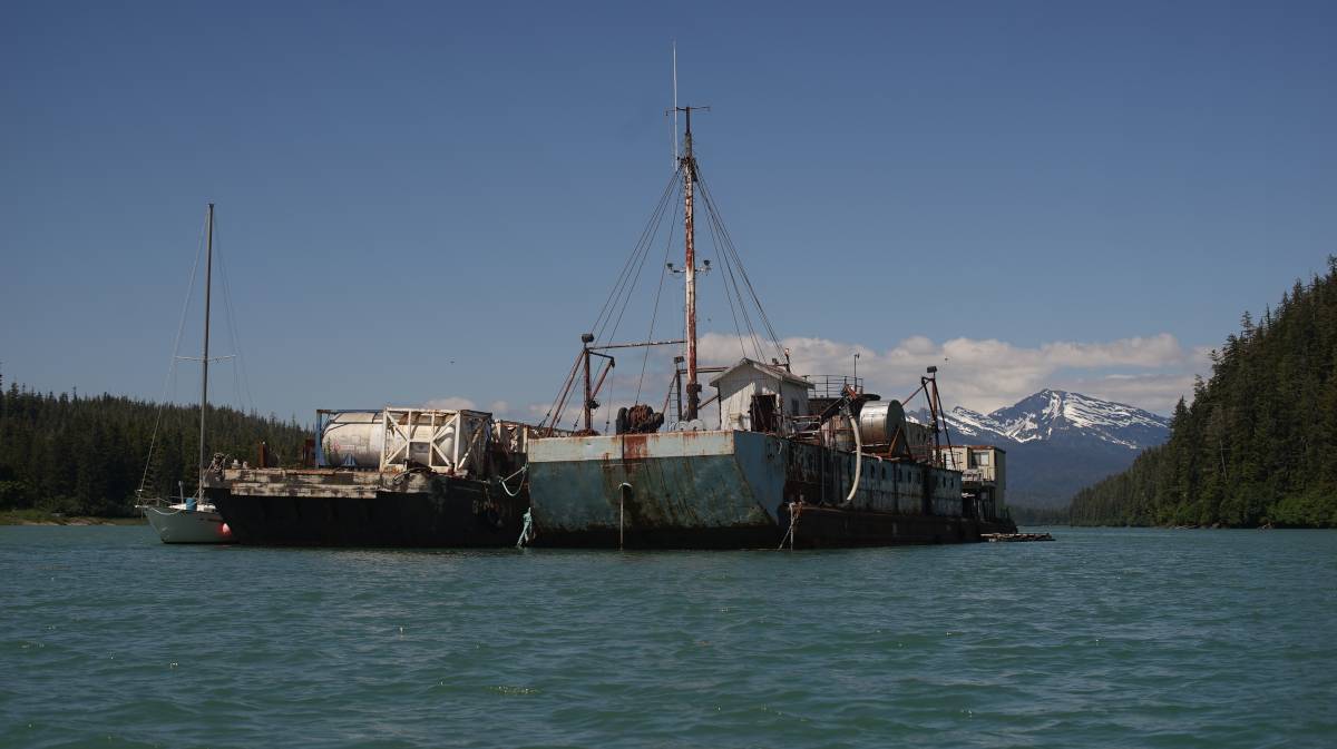 a rusty barge moored in the south anchorage, with a house built on top