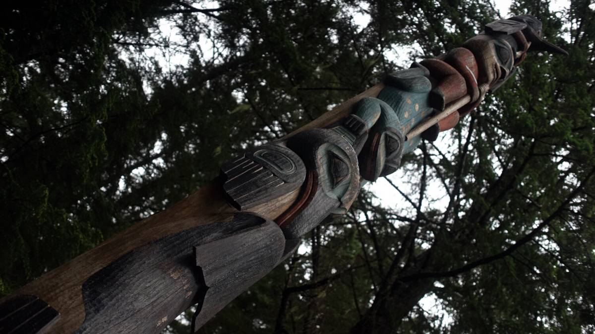 a totem pole featuring ravens and a whale